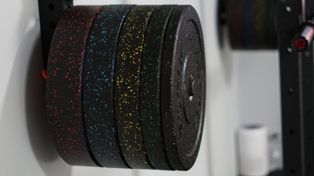 Set of weight plates on a weight rack in a gym setting