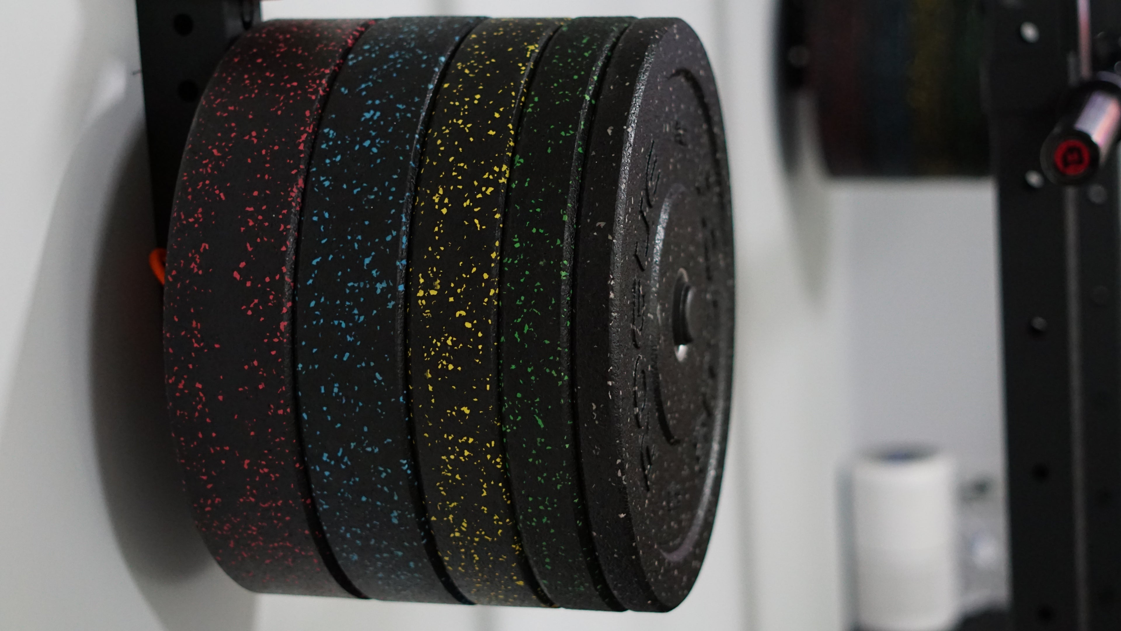 Set of weight plates on a weight rack in a gym setting